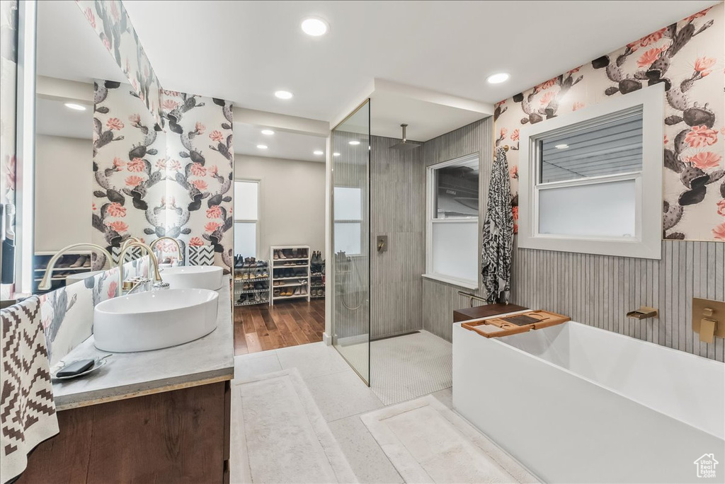 Bathroom featuring vanity with extensive cabinet space, independent shower and bath, and tile flooring