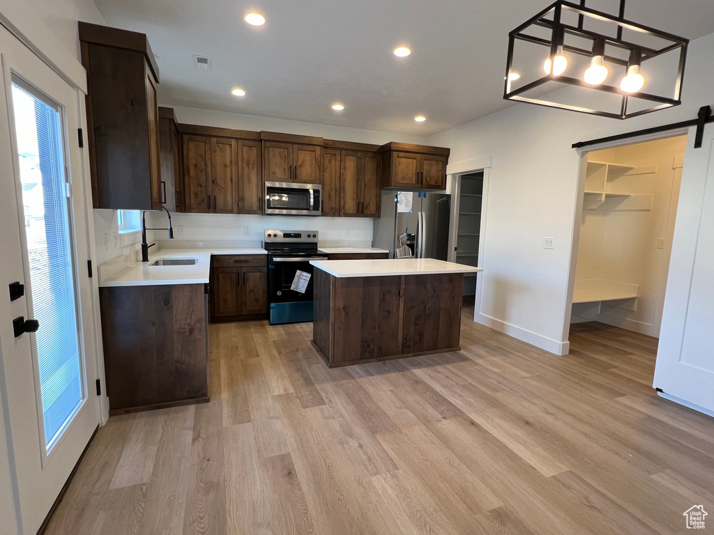 Kitchen featuring a center island, stainless steel appliances, and light wood-type flooring
