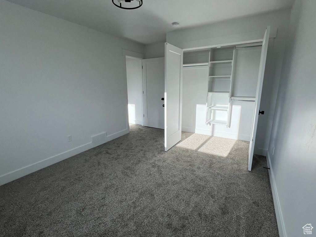 Unfurnished bedroom featuring carpet flooring and a closet