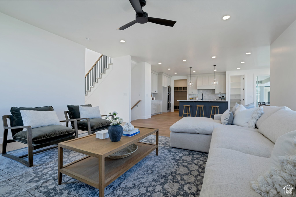 Living room with light hardwood / wood-style floors and ceiling fan