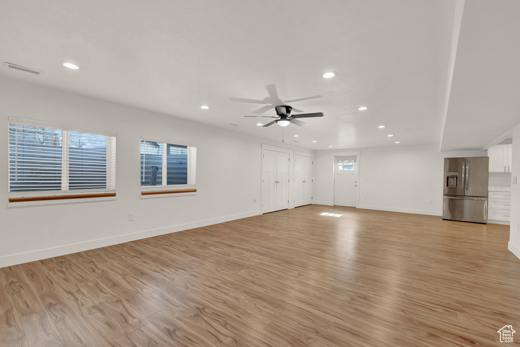 Spare room featuring light hardwood / wood-style flooring, a wealth of natural light, and ceiling fan