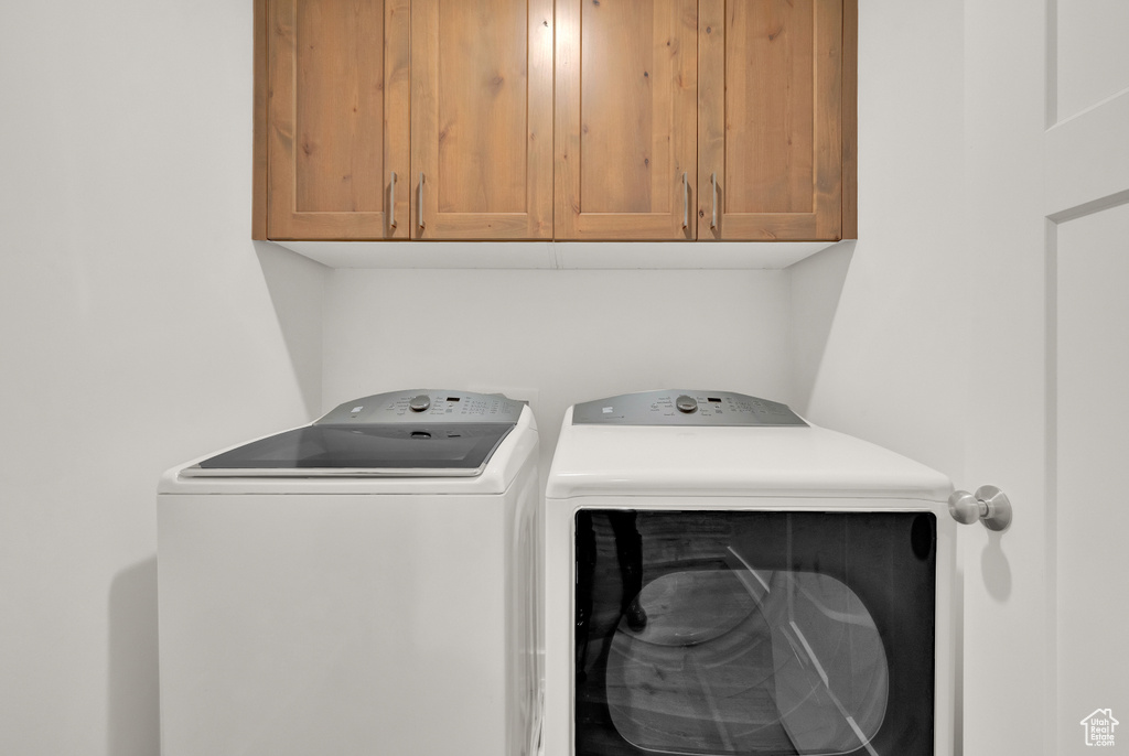 Laundry area with cabinets and washer and clothes dryer
