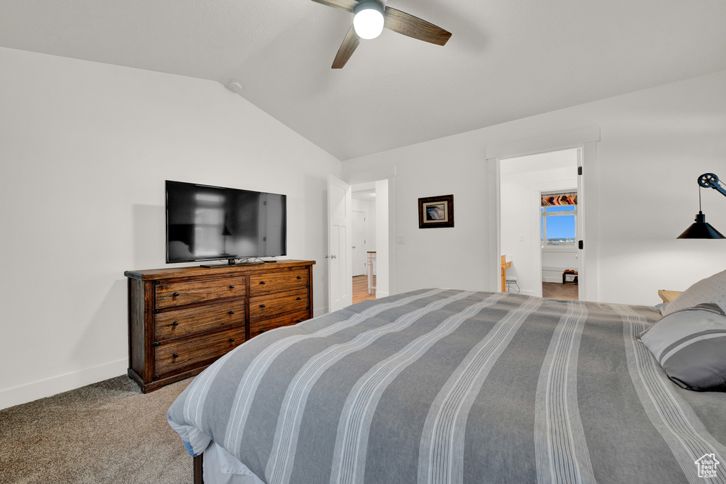 Bedroom with ceiling fan, dark colored carpet, and lofted ceiling