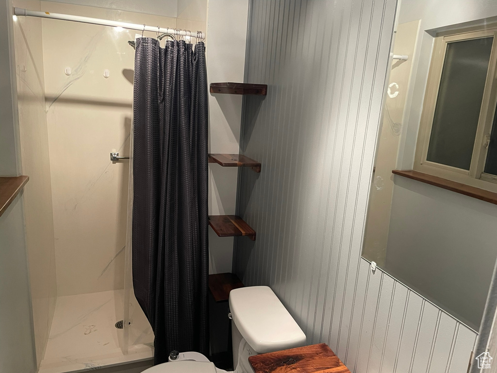 Bathroom with toilet and a shower with shower curtain