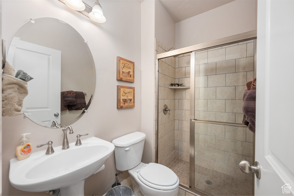 Bathroom featuring walk in shower, toilet, and sink