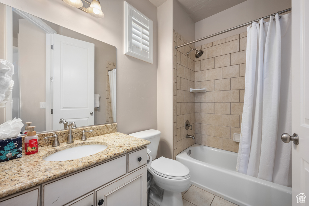 Full bathroom with tile flooring, vanity, toilet, and shower / bathtub combination with curtain