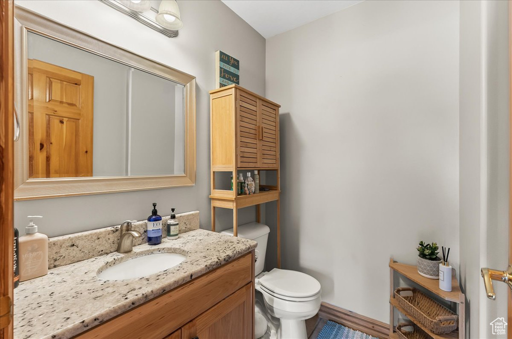 Bathroom featuring large vanity and toilet