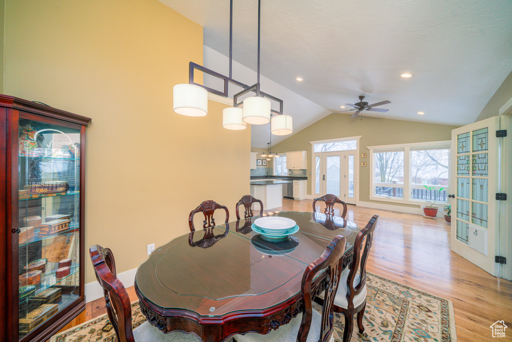 Dining space with french doors, vaulted ceiling, ceiling fan, and light hardwood / wood-style floors