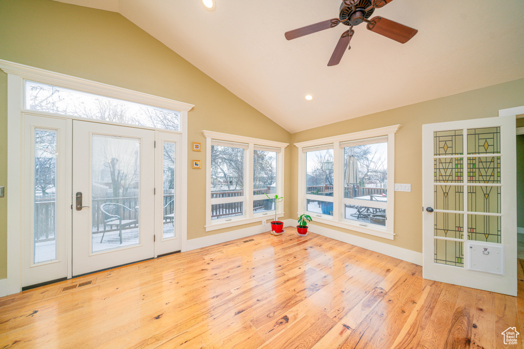 Unfurnished sunroom with a healthy amount of sunlight, lofted ceiling, and ceiling fan