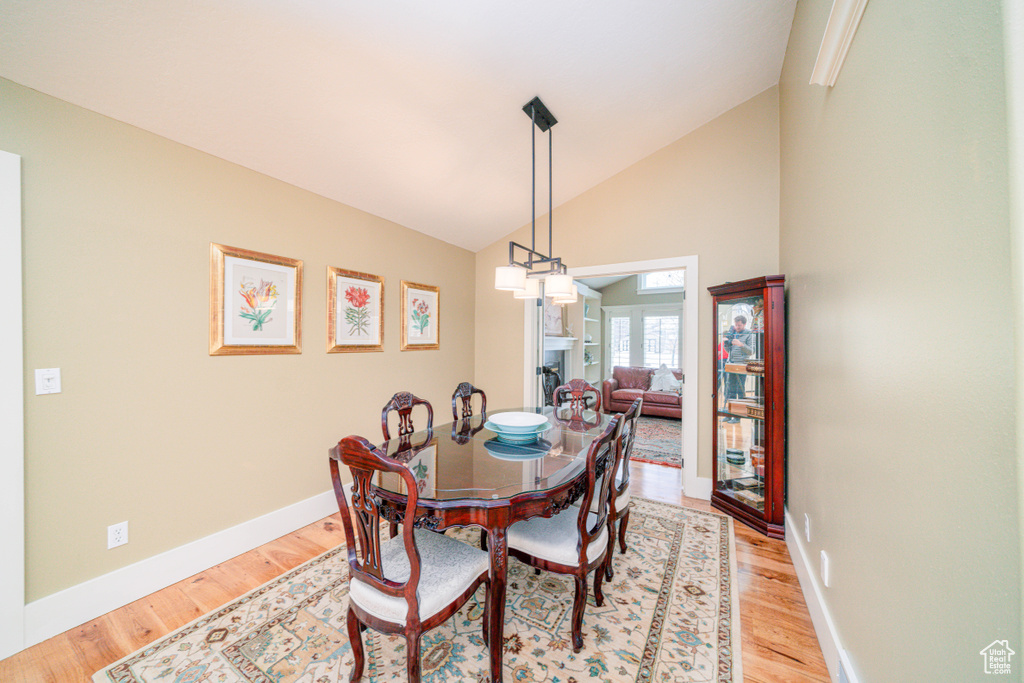 Dining room featuring high vaulted ceiling and light hardwood / wood-style floors