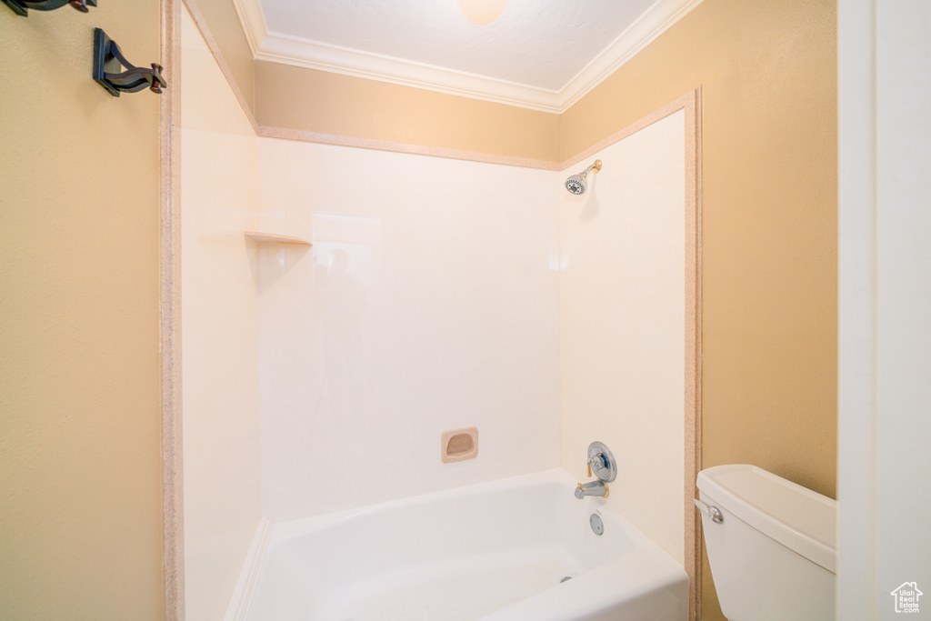 Bathroom with shower / tub combination, ornamental molding, and toilet