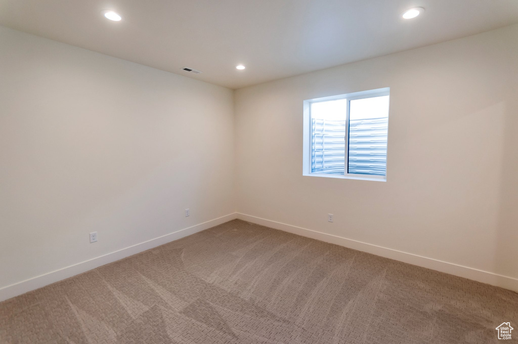 Unfurnished room featuring dark colored carpet