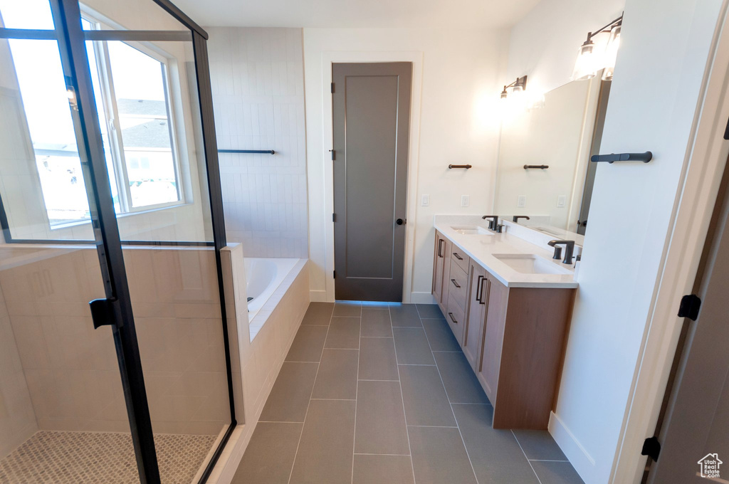 Bathroom featuring tile flooring, plus walk in shower, and double sink vanity