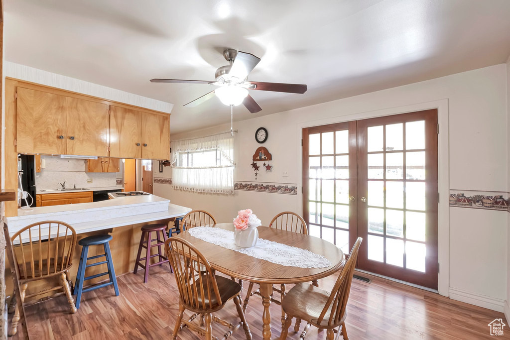 Dining space with ceiling fan, a healthy amount of sunlight, and hardwood / wood-style flooring