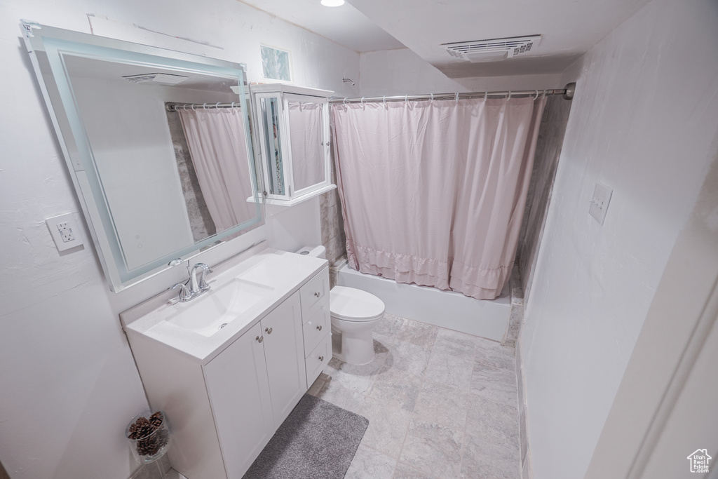 Full bathroom featuring toilet, tile floors, shower / tub combo, and large vanity