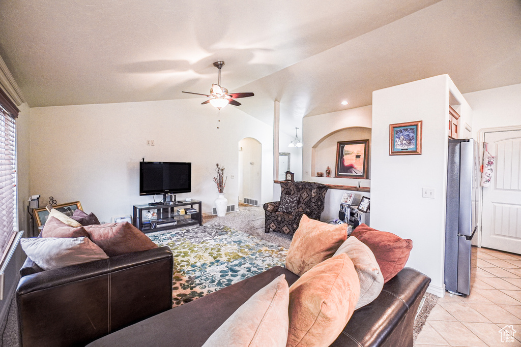 Living room featuring light tile flooring, ceiling fan, and vaulted ceiling