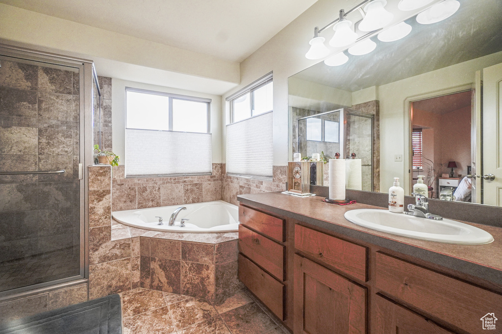 Bathroom featuring tile flooring, large vanity, and plus walk in shower