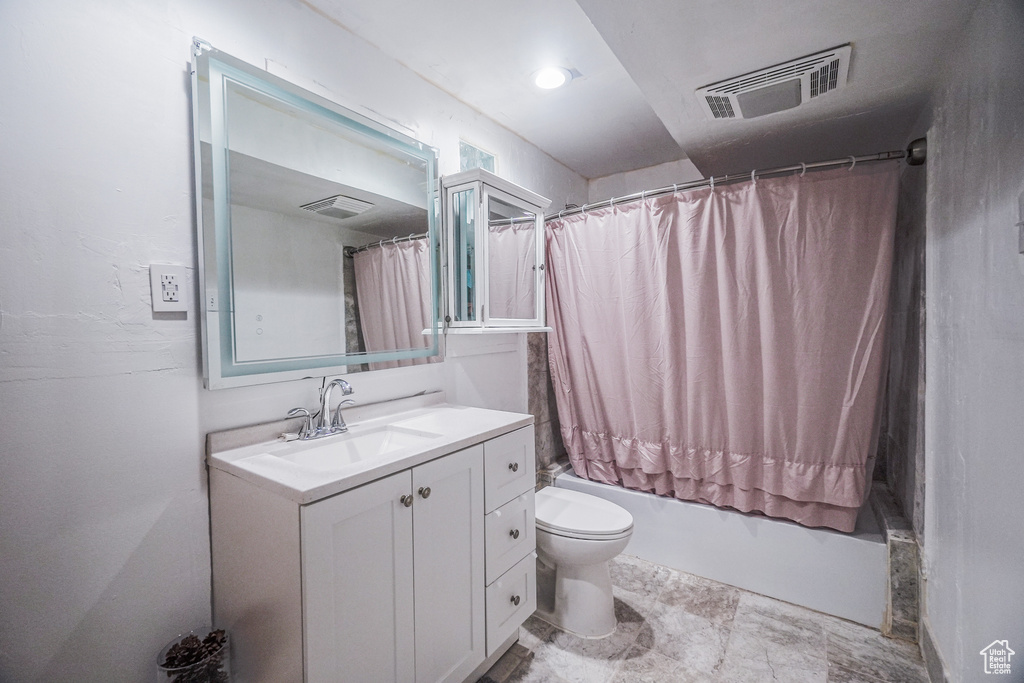 Full bathroom with shower / tub combo with curtain, vanity, tile flooring, and toilet