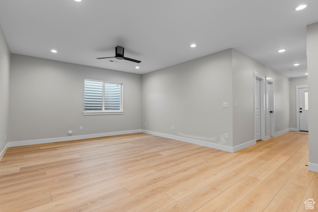 Empty room with light hardwood / wood-style floors and ceiling fan