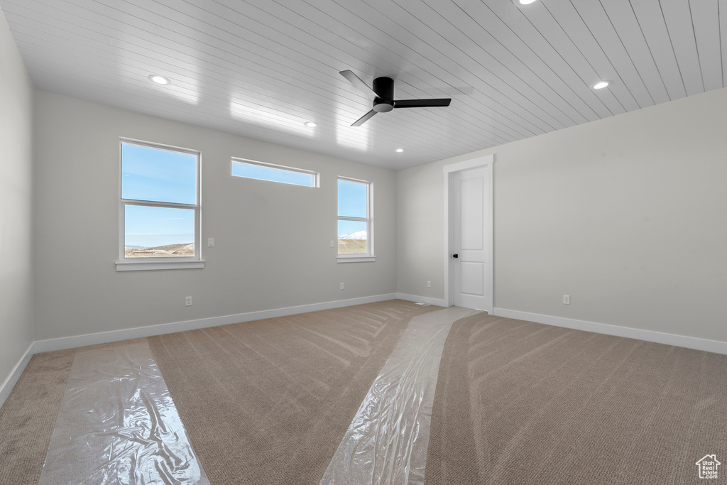 Unfurnished room featuring light colored carpet, wooden ceiling, and ceiling fan
