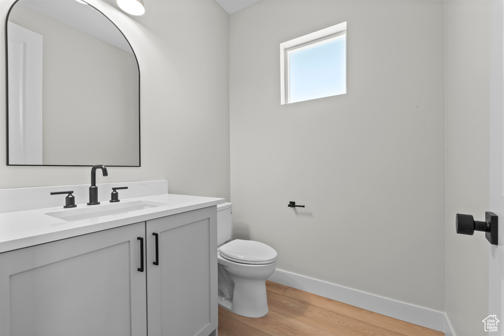 Bathroom featuring large vanity, hardwood / wood-style floors, and toilet