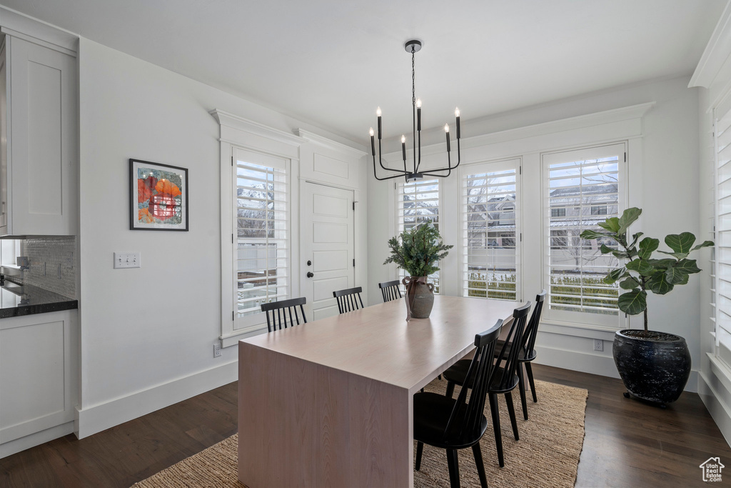 Dining area with a chandelier, dark hardwood / wood-style floors, and a wealth of natural light