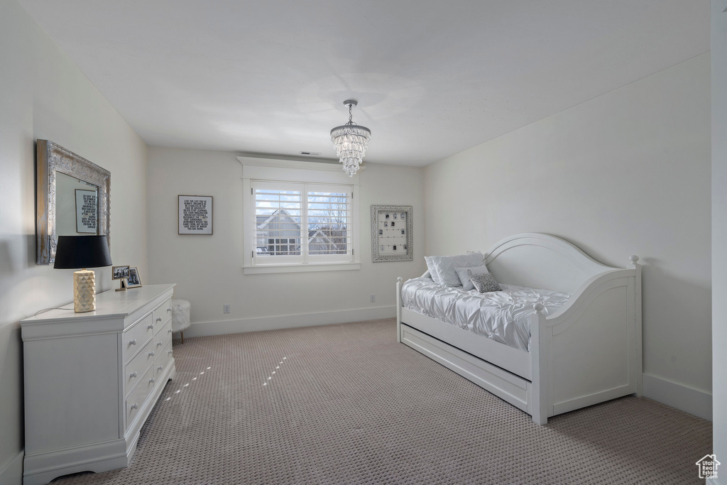 Bedroom featuring a notable chandelier and light carpet