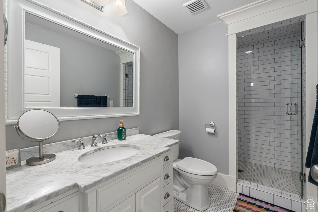 Bathroom featuring walk in shower, tile flooring, toilet, and vanity