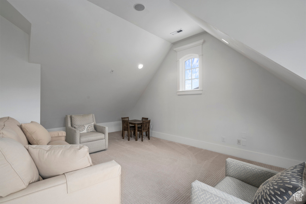 Living room with light colored carpet and vaulted ceiling
