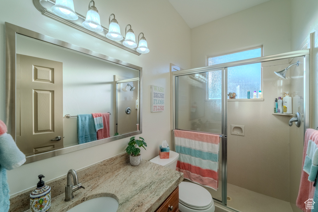 Bathroom featuring oversized vanity, walk in shower, and toilet