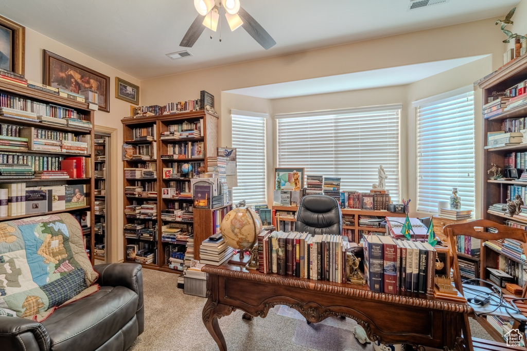 Carpeted home office featuring ceiling fan