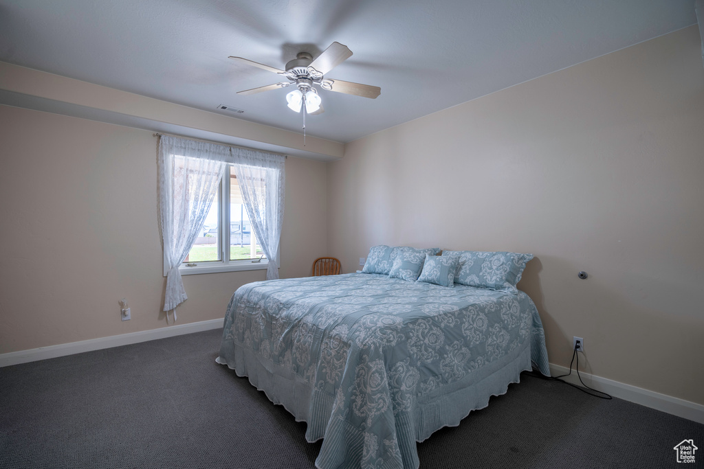 Bedroom featuring dark carpet and ceiling fan