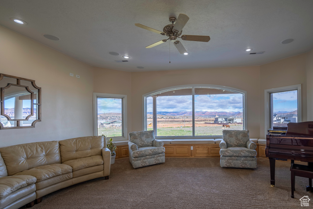 Living room featuring carpet flooring and ceiling fan