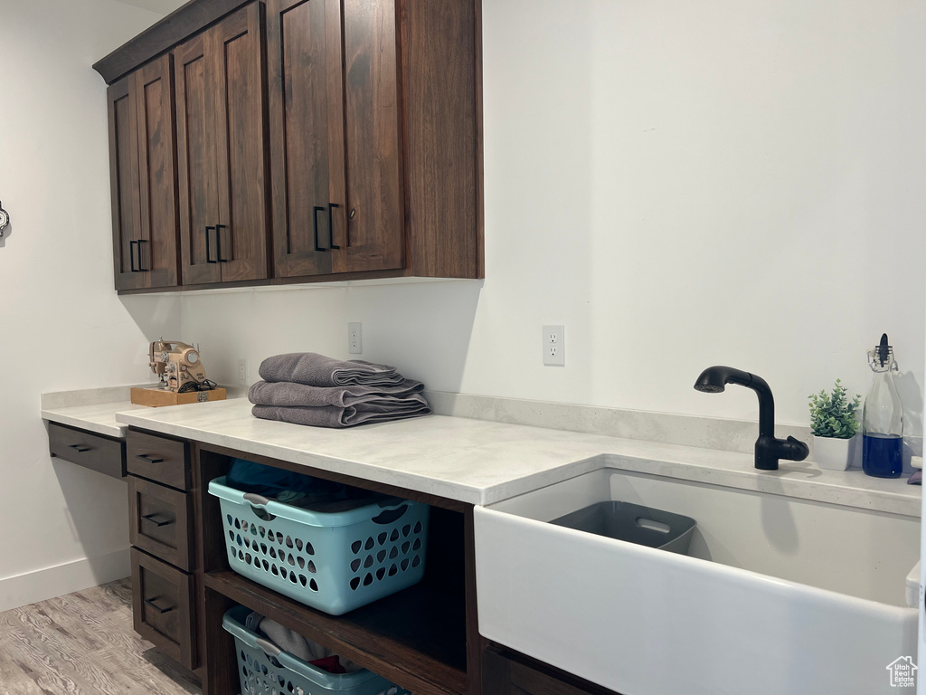 Laundry room featuring light hardwood / wood-style flooring and sink