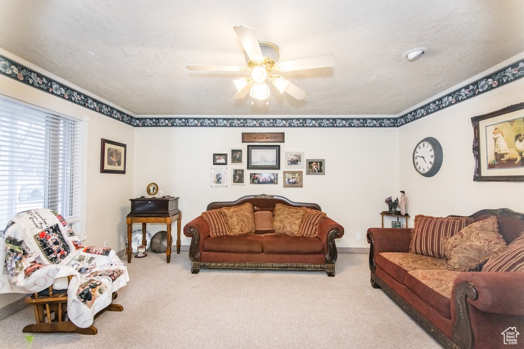 Living room featuring ornamental molding, light carpet, and ceiling fan