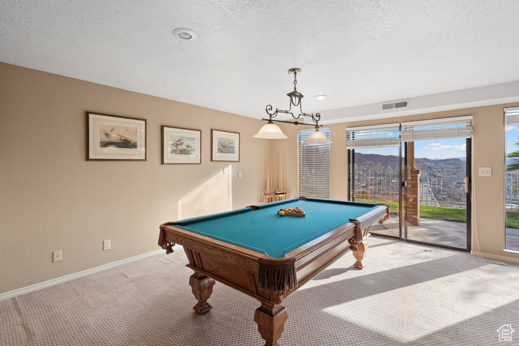 Game room with a textured ceiling, light carpet, and pool table