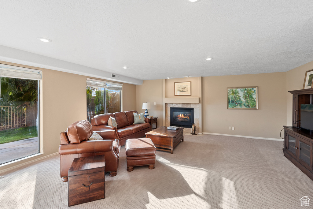 Carpeted living room with a fireplace and a textured ceiling