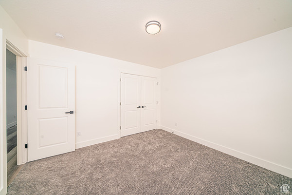 Unfurnished bedroom featuring carpet floors and a closet