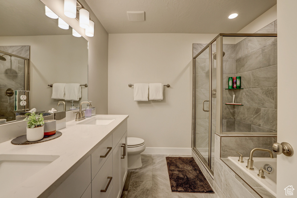 Full bathroom featuring independent shower and bath, double sink, tile floors, toilet, and oversized vanity