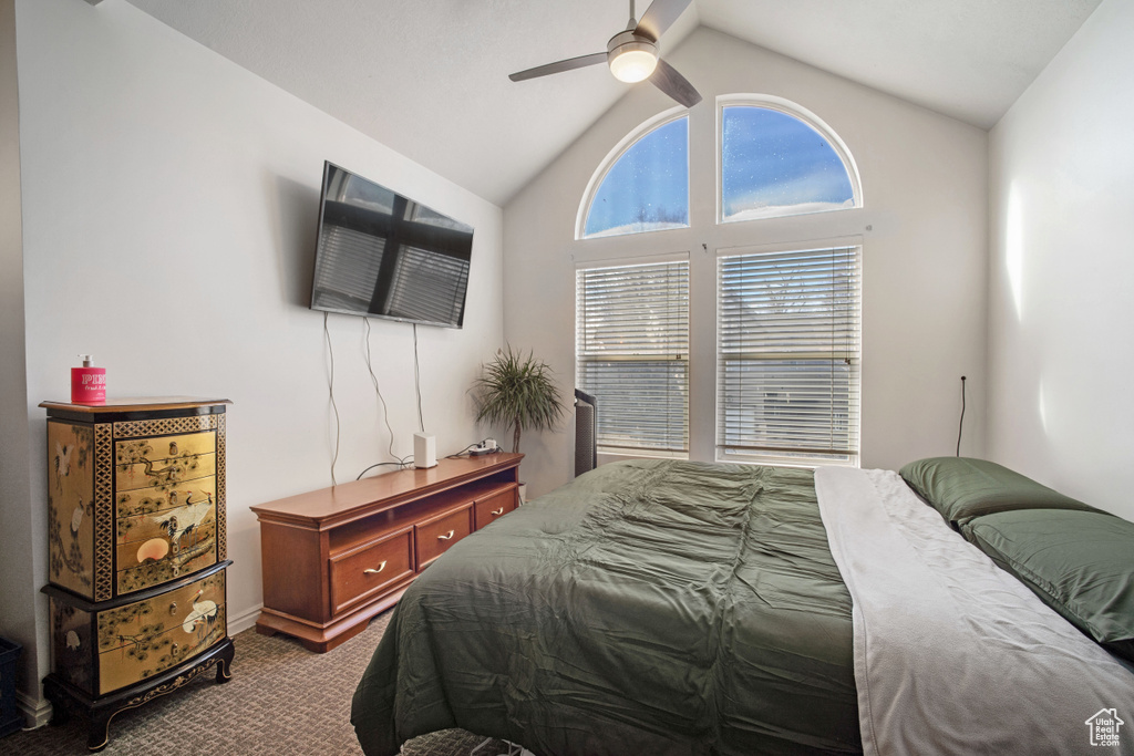 Bedroom featuring lofted ceiling, dark carpet, and ceiling fan