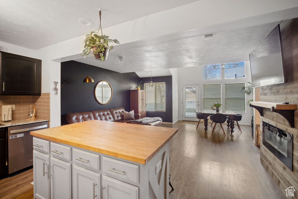 Kitchen featuring backsplash, dishwasher, light hardwood / wood-style floors, white cabinetry, and butcher block counters
