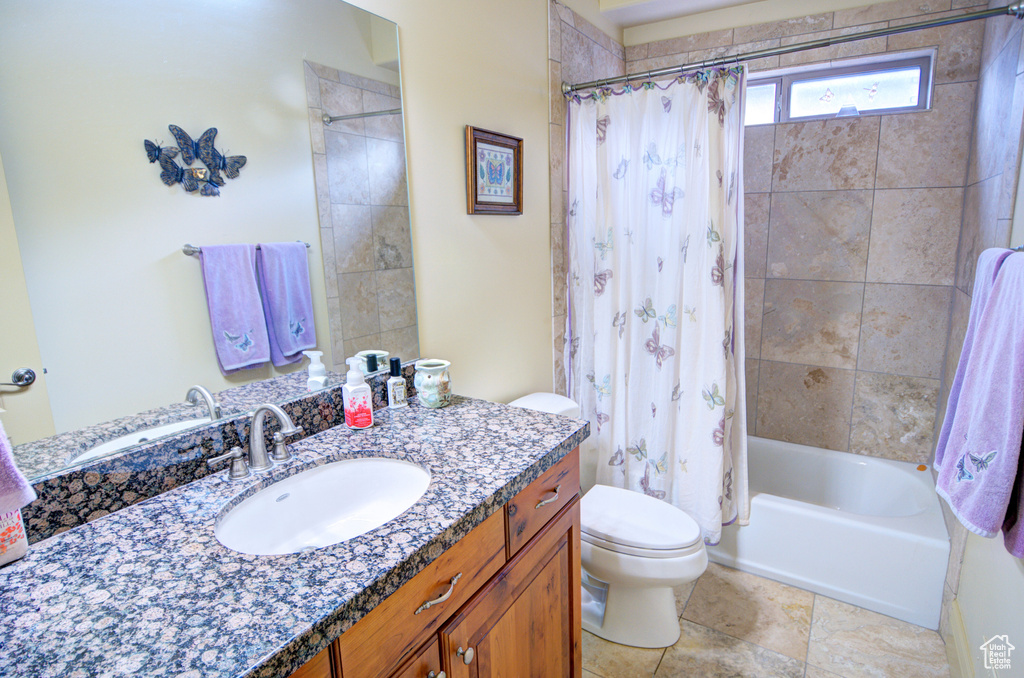 Full bathroom with shower / bathtub combination with curtain, oversized vanity, tile floors, and toilet
