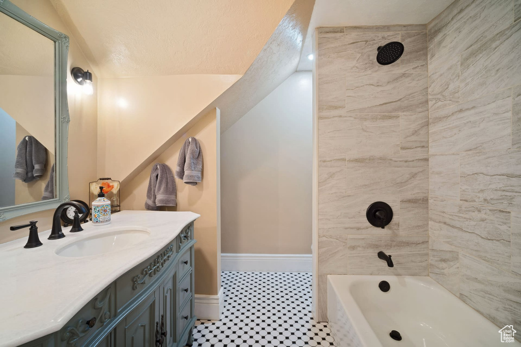 Bathroom with tile floors, tiled shower / bath, and oversized vanity