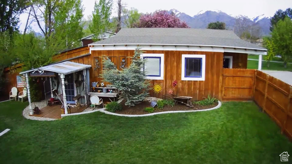 Rear view of property featuring a mountain view and a yard