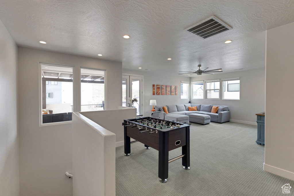 Recreation room with light carpet, a textured ceiling, french doors, and ceiling fan