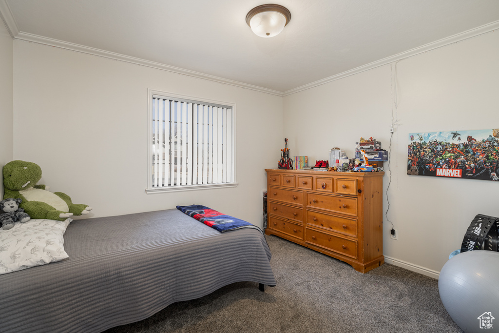 Bedroom with ornamental molding and dark carpet