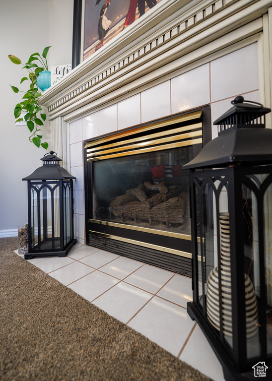 Details with light tile flooring and a fireplace