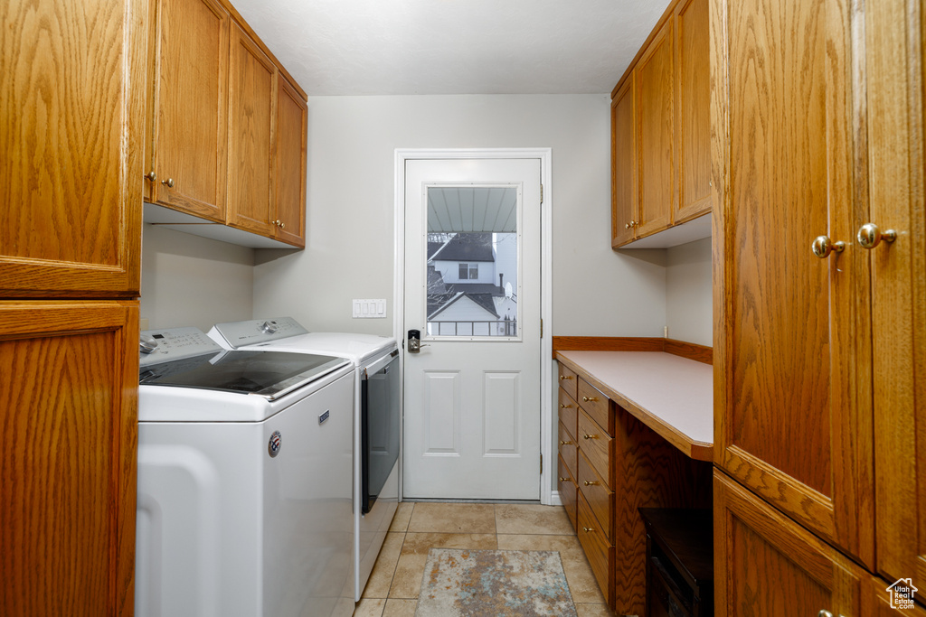 Laundry room featuring cabinets, washing machine and clothes dryer, and light tile flooring
