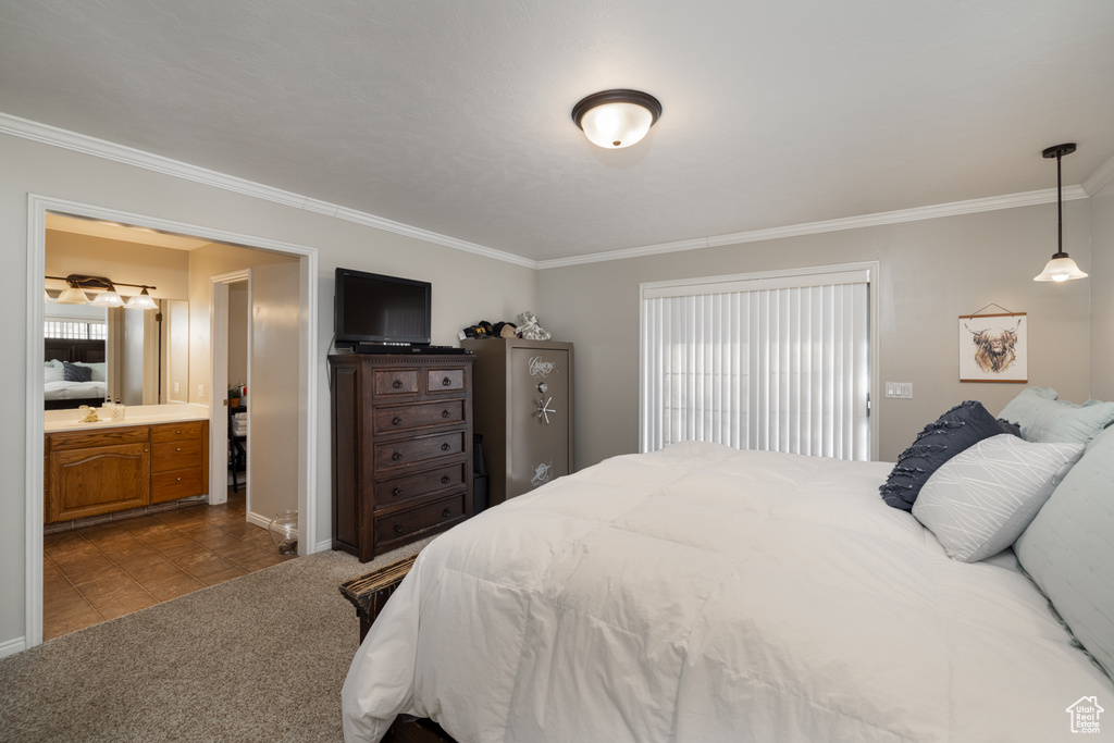 Carpeted bedroom with connected bathroom and crown molding