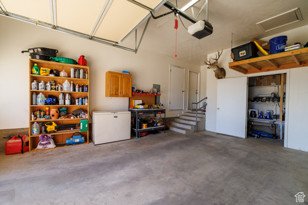 Garage with white refrigerator and a garage door opener